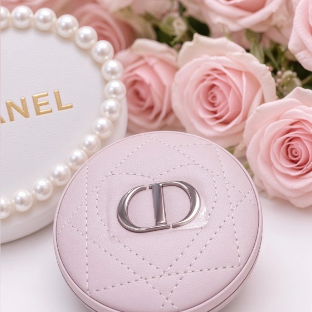 Makeup compact cases with Chanel and Dior branding among roses